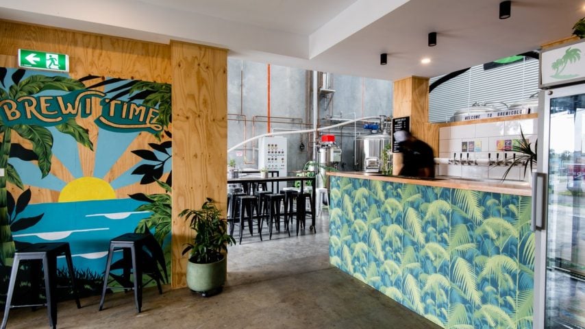 Inside at BrewiColo Brewing. Palm trees and colourful deco fill the front bar.