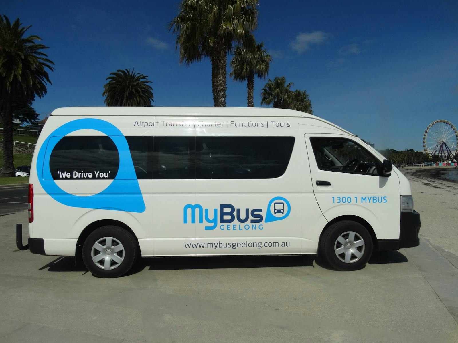 A MyBus Geelong van is parked at Geelong waterfront, the palm trees are in the background.