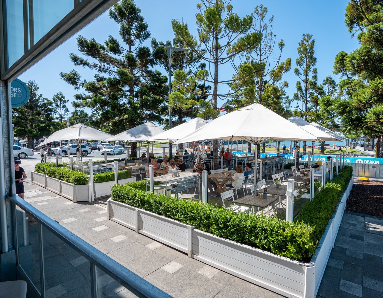Sailors Rest al fresco terrace, with umbrellas, tables and views of the bay.