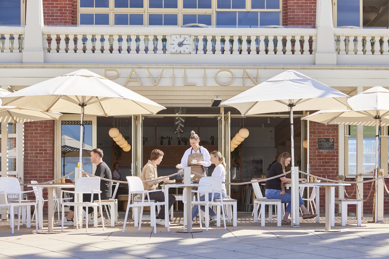 Al fresco dining at Pavilion Geelong, a waitress serves a couple sitting outside.