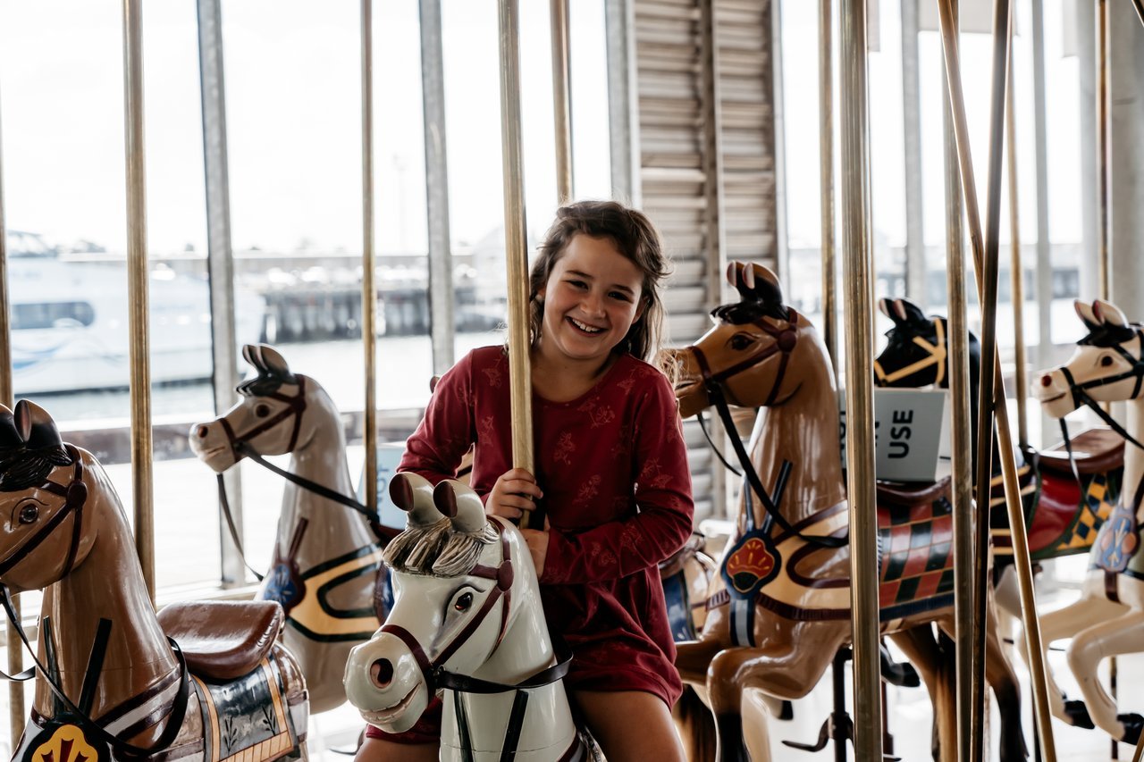 Young girl enjoying herself on the Geelong Carousel, the original hardware creating a unique memory experience