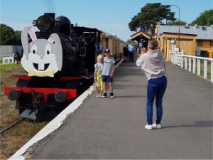 Train with Easter bunny decal on the front, with 2 children posing for photo with Mum taking photo