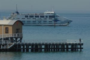 Ferry sailing in waters with pier in front