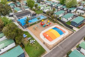 Aerial shot of holiday park with jumping pillow, outdoor pool