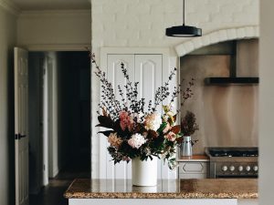 Vase of flowers sat on counter top in kitchen